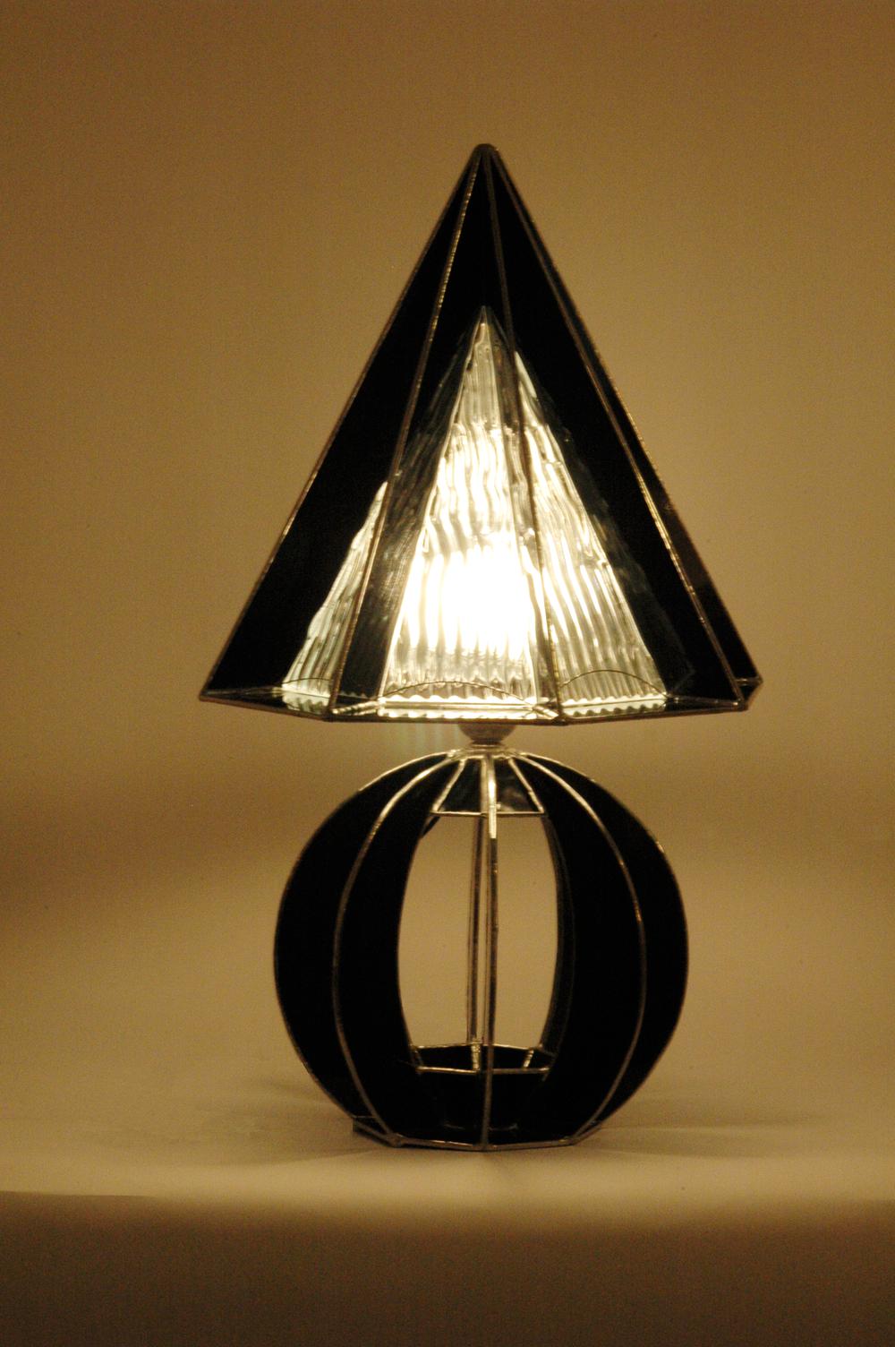 Les vitraux noirs aux formes originales apportent son caractère à cette petite lampe de bureau.